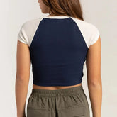 Person wearing a navy and white crop top with beige pants